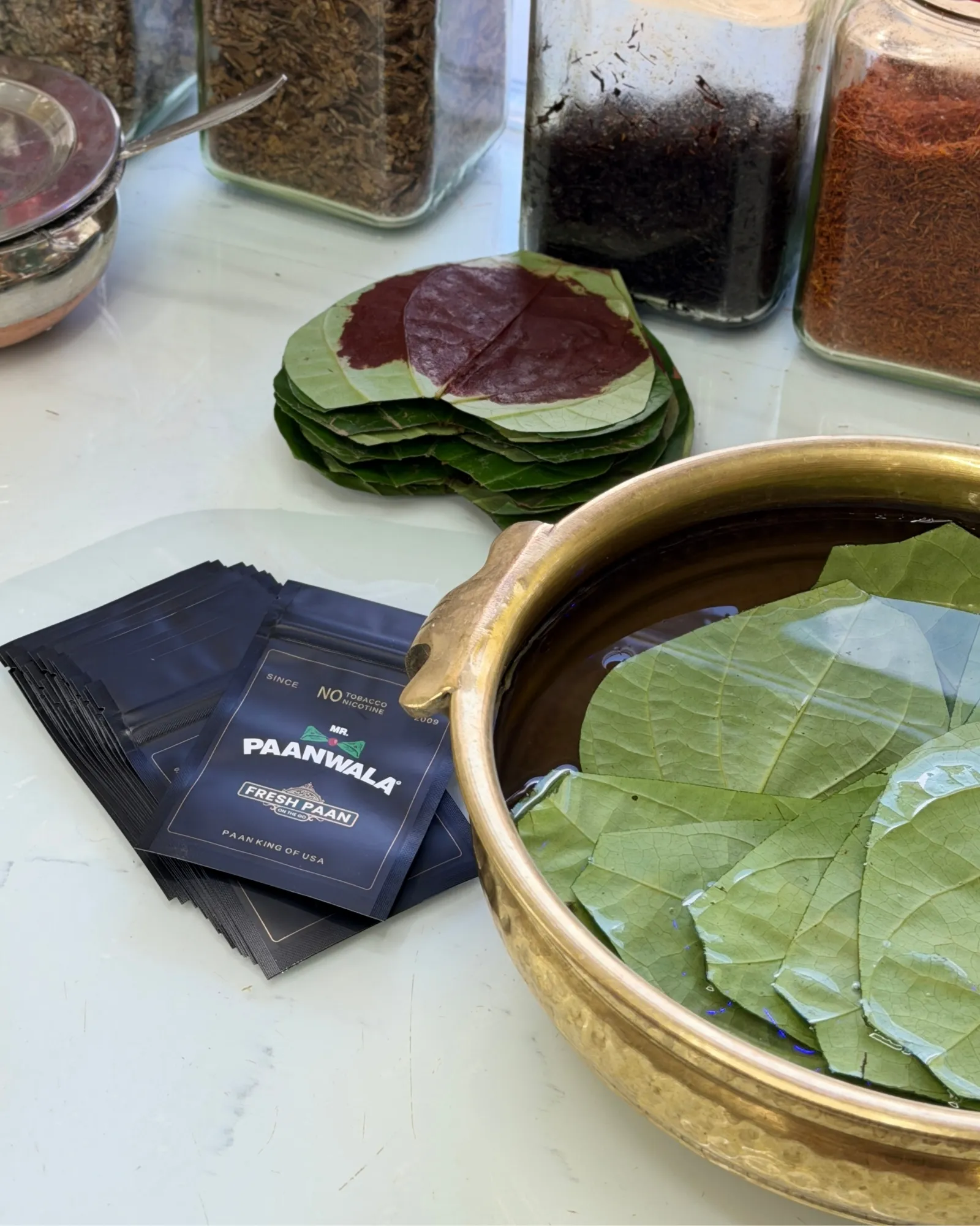 Fresh betel leaves in a brass bowl with Mr.Paanwala packs
